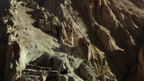 People visiting an ancient monastery carved into the mountainside Video stock 335077642