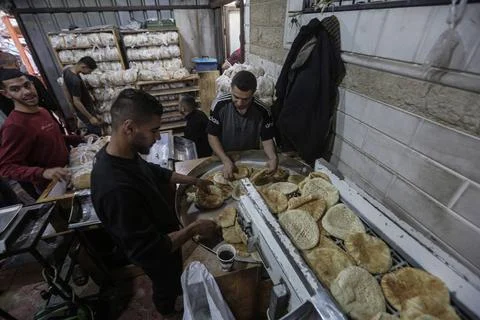  People wait in crowded lines for hours to buy bread at a bakery operating... Stock Photos