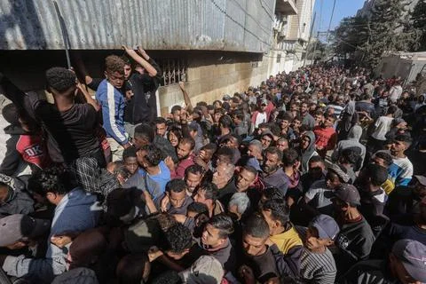  People wait in crowded lines for hours to buy bread at a bakery operating... Stock Photos
