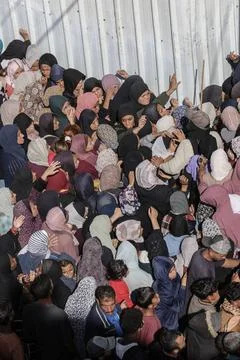  People wait in crowded lines for hours to buy bread at a bakery operating... Stock Photos