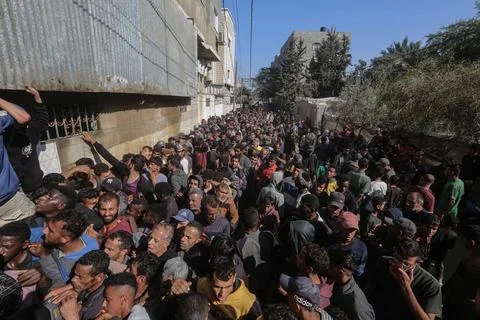 People wait in crowded lines for hours to buy bread at a bakery operating... Stock Photos