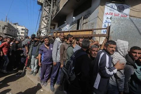  People wait in crowded lines for hours to buy bread at a bakery operating... Stock Photos