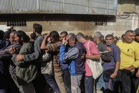  People wait in crowded lines for hours to buy bread at a bakery operating... Stock Photos