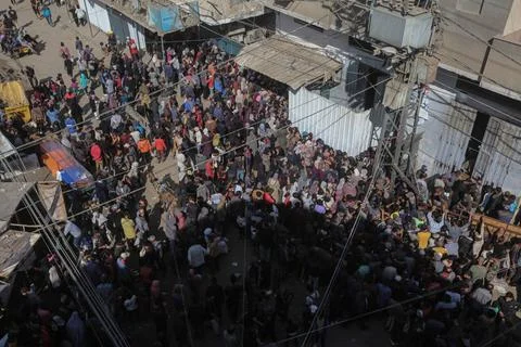  People wait in crowded lines for hours to buy bread at a bakery operating... Stock Photos