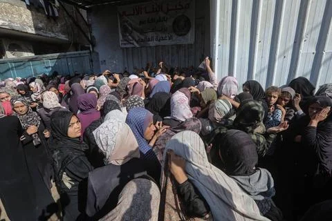 People wait in crowded lines for hours to buy bread at a bakery operating... Stock Photos