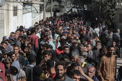  People wait in crowded lines for hours to buy bread at a bakery operating... Stock Photos