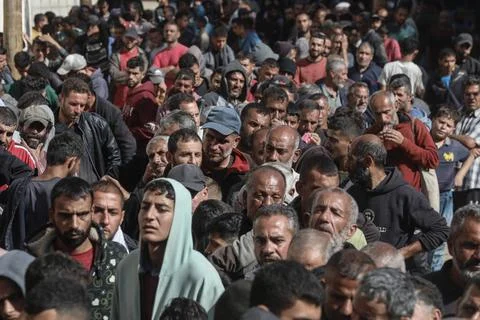  People wait in crowded lines for hours to buy bread at a bakery operating... Stock Photos