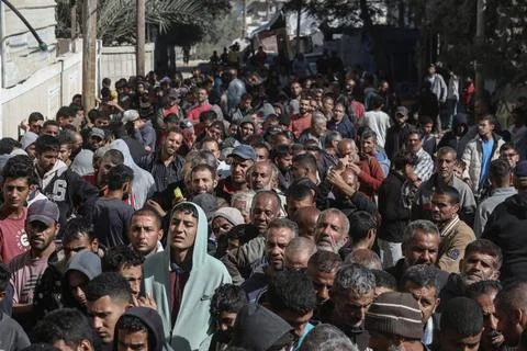  People wait in crowded lines for hours to buy bread at a bakery operating... Stock Photos