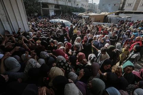  People wait in crowded lines for hours to buy bread at a bakery operating... Stock Photos
