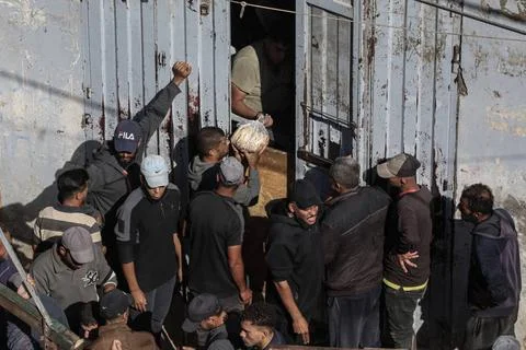  People wait in crowded lines for hours to buy bread at a bakery operating... Stock Photos