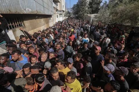  People wait in crowded lines for hours to buy bread at a bakery operating... Stock Photos