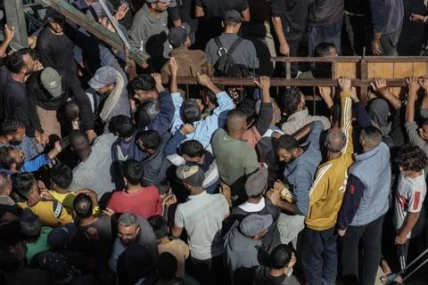  People wait in crowded lines for hours to buy bread at a bakery operating... Stock Photos