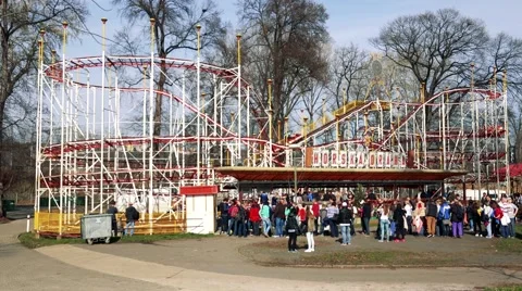 People wait in front of big roller-coaster in funfair Stock Footage 62175139