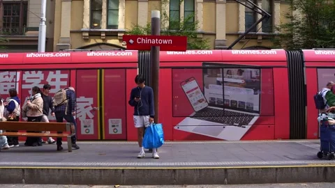 People wait for the light rail tram on the platform at Chinatown station in Stock Footage 339837195