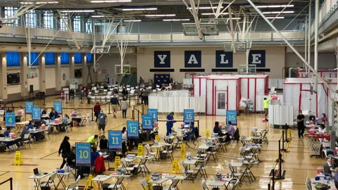 People wait in line inside a Yale COVID-19 Vaccine Clinic Station 2021 Video stock 152181832