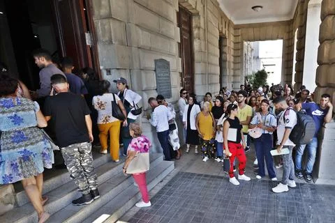 People wait outside the Spanish Consulate in Havana amid uncertanty over, Cuba - Stock Photos
