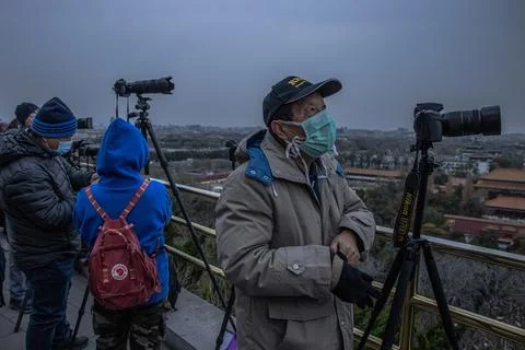 People wait to see the partial lunar eclipse in Beijing, China - 19 Nov 2021 Stock Photos