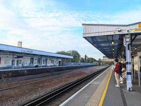 People wait for their train on a platform at Canterbury West station under a Stock Photos