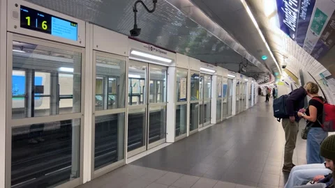 People wait for a train to arrive at a modern metro station Denfert-Rochereau Stock Footage 311936522
