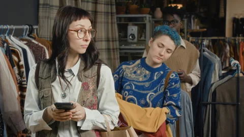 People Waiting in Line to Pay for Secondhand Clothes in Modern Thrift Store Stock Footage 328368904