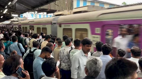 People waiting for the local train to arrive at a busy station platform in India Stock Footage 341455702