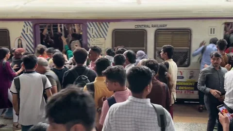 People waiting for a local train to arrive at a busy station platform in Mumbai 動画素材 341455751