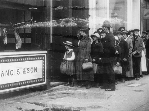 People waiting in queue to enter shop, policeman let's them in, UK 1918 Video stock 133387442