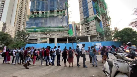People waiting in queue on a street in Mumbai Stock Footage 228045228