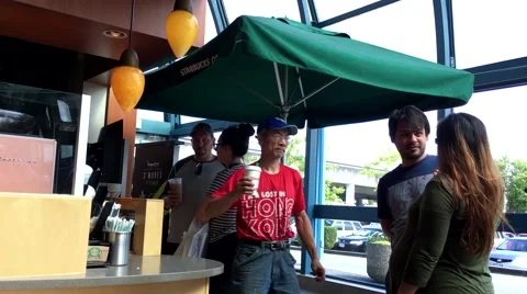 People waiting for their coffee inside Starbucks store Stock Footage 65007076
