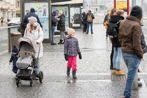 People waiting walking the platform while waiting descending for tram on a sn Stock Photos
