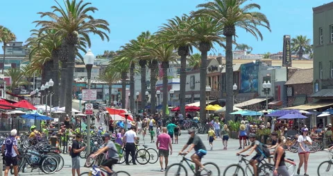 People wak and riding bicycles near Hermosa Beach Pier in Los Angeles, 4K Stock Footage