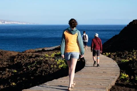 People walk along the path to the ocean on the island of Tenerife Stock Photos