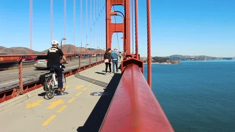 People Walk and Cycle Past on the Golden Gate Bridge in San Francisco California Stock Footage