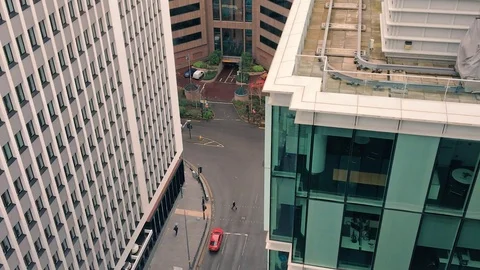 People walk like ants between two modern towering office blocks in Birmingham 動画素材 79074247