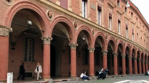 People walk by the arcade at Piazza Santo Stefano in Bologna, Italy. Video stock 59792744