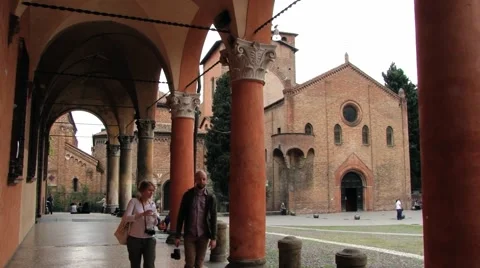 People walk by the arcade at Piazza Santo Stefano in Bologna, Italy. Video stock 59792760