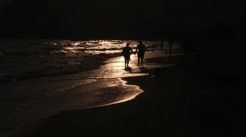 People walk on the beach at sunset Stock Footage