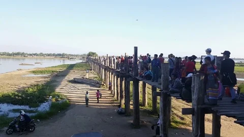 People walk on crowded U Bein Bridge side angle shot, Taungthaman Lake, Mandalay Vídeos de archivo 79618672