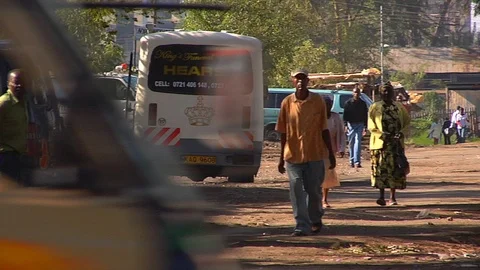 People walk down busy side street in Nakuru, Kenya. Stock Footage 99425735