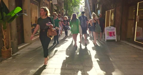 People walk down the narrow mediaeval streets of the Gothic quarter in Barcelona Stock Footage 231807306