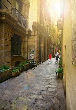 People walk down a quiet pedestrian street in Barcelona Spain Stock Photos