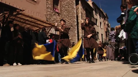 People walk with flags during Medieval festival in Montblanc, Spain. Stock Footage 61752609