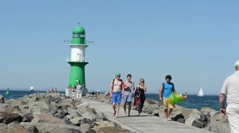 People walk to the lighthouse of Warnemünde. Video stock 36161792