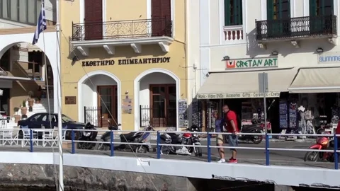 People walk passed shops harbour side restaurants Stock Footage 85299448