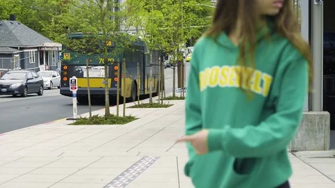 People walk past as others wait for bus in the background. Stock Footage 73496905