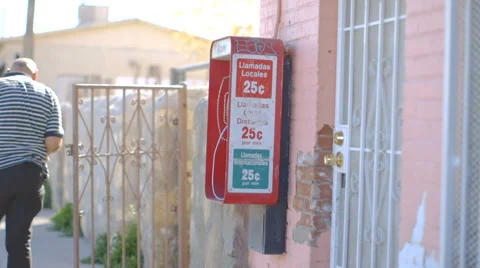 People Walk by Red Pay Phone in Border Town Stock Footage 60129211
