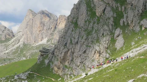 People walk in a row on a mountain path Stock Footage 177479873