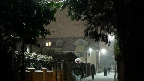 People walk in snow fall / Epsom, Surrey, Uk at night winter Febr. 2018 Video stock 103587641
