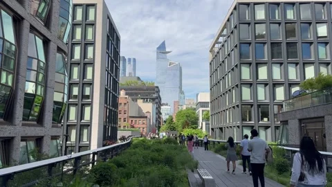 People walk through High Line. Hudson Yards skyscrapers. New York City skyline Stock Footage 336502904