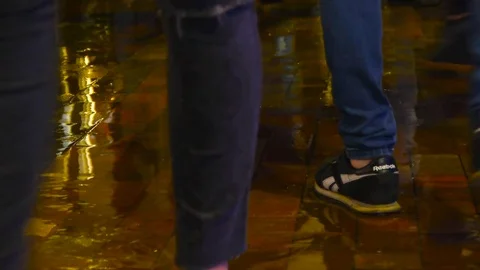 People walk through a puddle on the road, people enter a puddle Video stock 84252375